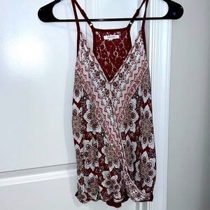 Criss cross flowy material in the front with lace halter backing. Rust color